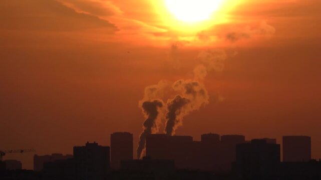 Time-lapse view of a scorching sun due to a heat wave, with buildings in the city emitting smog and pollution.