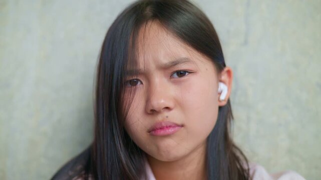 anxious worried teen girl with her smartphone as a conceptual footage for cyberbullying social media trauma, teenager mental health crisis, depression and panic attack