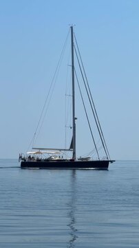 Sailboat gliding across calm Adriatic Sea on peaceful summer day in Croatia. Sailing on smooth blue water represents freedom, serenity and slow travel