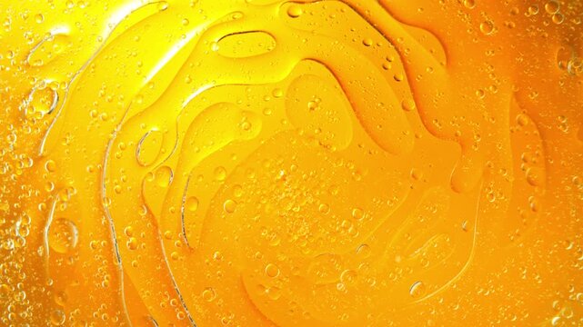 Super Slow Motion Shot of Swirling Golden Oil Patterns in Water at 1000fps. Cosmetic Background.