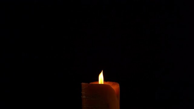 The big candle is burning. It is brighter.