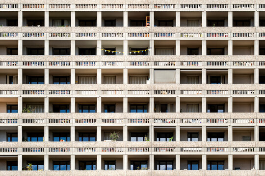 Repetitive balconies and windows form a geometric pattern across a building facade creating an abstract architectural background for graphic use