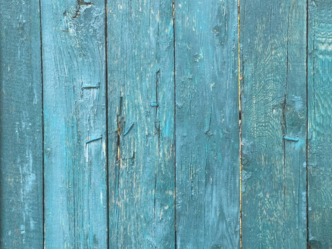 Weathered blue wooden planks with peeling paint and a rustic textured surface