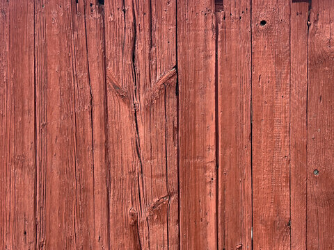 Weathered reddish wooden planks with pronounced grain, knots and a rustic aged texture