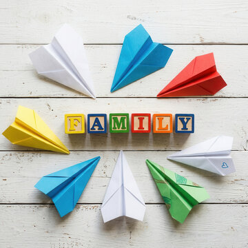 Colorful Paper Airplanes Arranged Around The Word Family Blocks