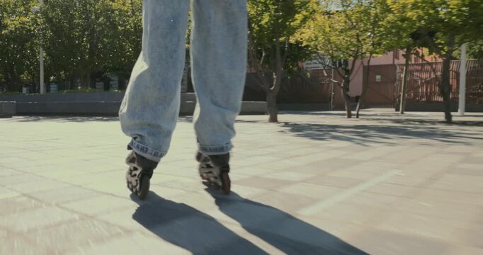 Close-up view of young woman rollerblading across sunny urban plaza with smooth confident energy. Urban sport, active lifestyle and freedom concept.