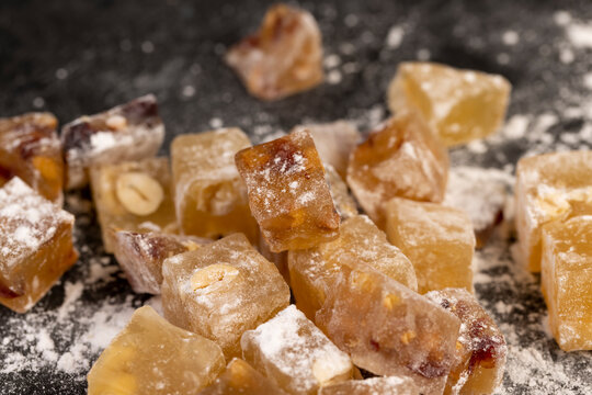soft and fresh Turkish delight sprinkled with a small amount of white sugar, cubic sweet white soft pieces of Turkish delight with nuts and dried fruits, yellow-orange sweetness