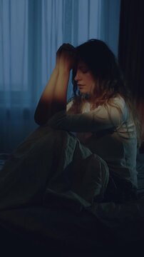black silhouette sad woman sitting on bed can't sleep suffering from headache in dark room. head ache health problem. girl feels bad, ill after party, crying distressed over the divorce makes decision