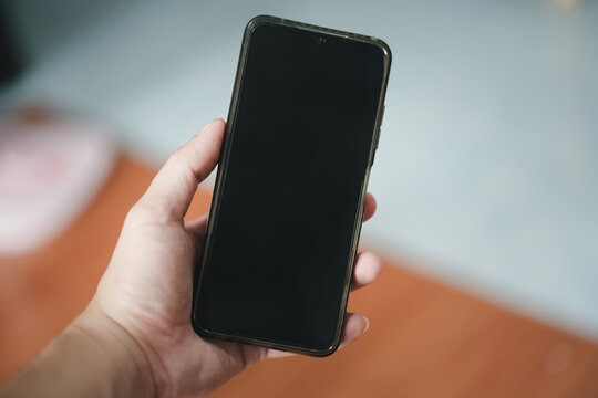 Man using smartphone blank screen modern design while lying on the sofa in living room 
