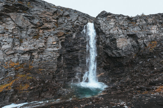 Arctic waterfall cascading down dramatic rocky cliffs in Northern Norway