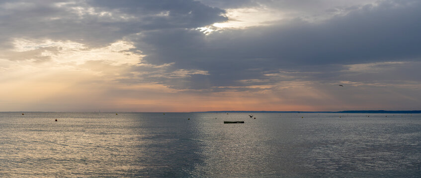 Langrune-Sur-Mer, France - 08 09 2026: Panoramic view of the sea, land and the sky with a ray of light reflecting on the water in the morning