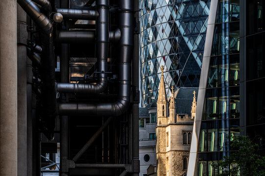 Industrial pipes and layered architecture in The City of London England combining mechanical detail with historic and modern urban buildings