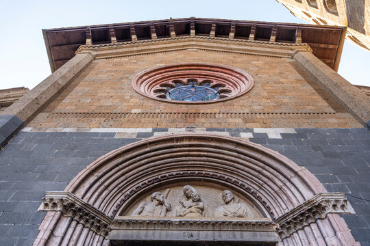 Sculpted lunette by artist Antonietta Paoli Pogliani, executed around 1928 on the facade of the Church of Sant'Andrea and Bartolomeo, viewed from below, Orvieto, Umbria, Italy