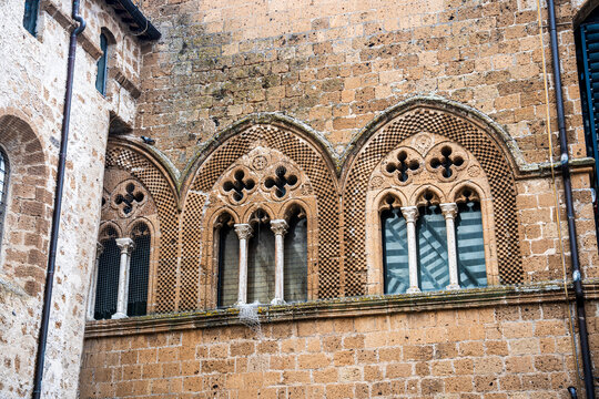 Detail of pointed triple lancet windows on the Episcopal Palace behind Orvieto Cathedral, a historic building associated with the city's medieval ecclesiastical complex, Orvieto, Umbria, Italy