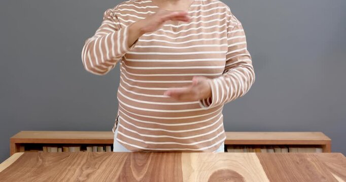 Close up of people talking to the camera, gesturing with hands, person in striped shirt standing beh