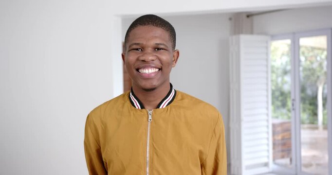 High speed photography for dynamic scenes, Smiling young man in yellow jacket standing indoors, look