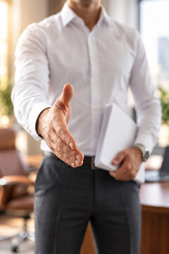 Businessman Extending Hand for Handshake During Job Interview in Modern Office
