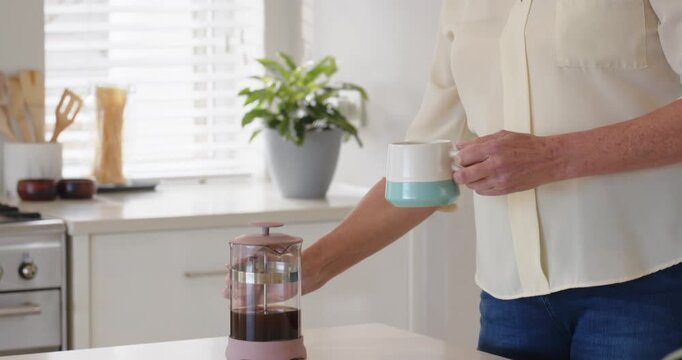 Lifestyle videos indoor of people doing activities at home, Holding mug, senior woman enjoying hot b