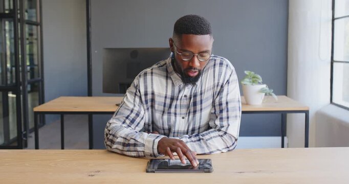 Businessman discussing strategy while using tablet in modern office setting