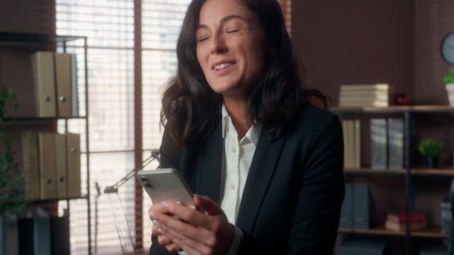 Shocked Caucasian business woman holding mobile phone in office excited businesswoman celebrating good news victory female happy winning success smartphone message amazing prize employee yes emotion
