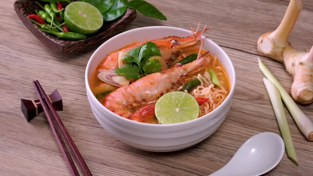 Instant noodles, Tom Yum Goong spicy shrimp soup In a white bowl. on a wooden table