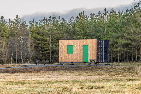 Wood-clad converted container unit serving area in community woo