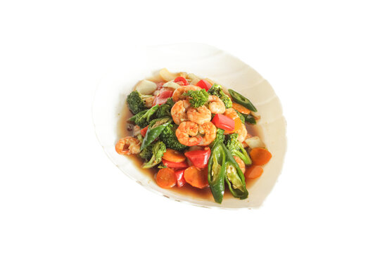 Stir fried shrimp with broccoli carrots and peppers served on plate isolated on plain background