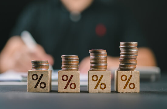 Interest rate finance and mortgage rates. Wooden block with percentage sign on many level of stack of coin. Financial growth, interest rate increase, inflation, sale price and tax rise concept.