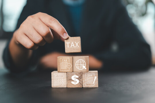 Hand putting tax icon in the wooden cube for income tax return and submit tax for payment tax documents online to the government