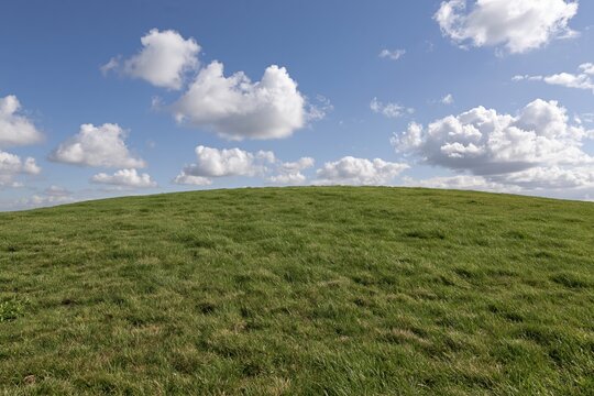 The Green Hill Landscape Under A Bright Sky With Soft White Clouds