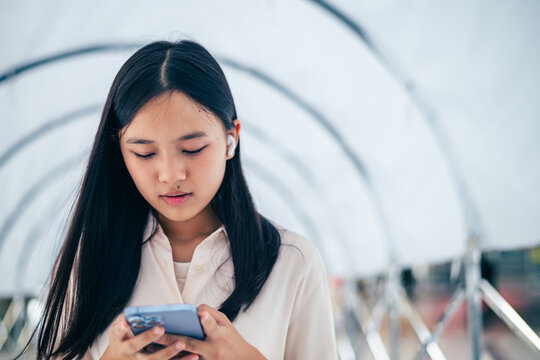 young woman texting and chatting on her smartphone as a conceptual backdrop for modern mobile communication technology lifestyle connectivity and digital nomad freedom with copy space