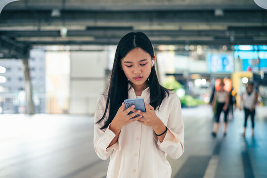 young woman texting and chatting on her smartphone as a conceptual backdrop for modern mobile communication technology lifestyle connectivity and digital nomad freedom with copy space