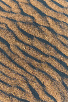 Sand Texture with Wave Pattern and Shadow at Golden Hour
