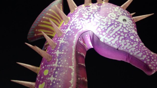 Colorful inflatable seahorse decoration displayed against a dark background. Purple patterned body, fins and pointed spikes create a distinctive underwater themed design.