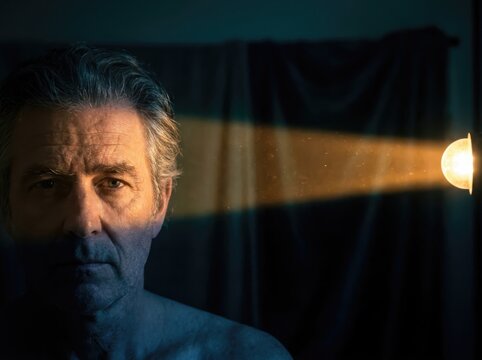Moody gentleman portrait with dramatic side light in dark interior