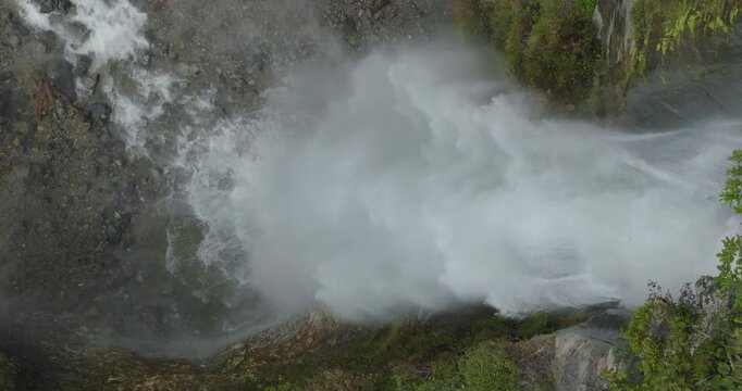 Martadi Bajura Nepal, aerial shot of dense white water mist, foam, and powerful water force exploding at the plunge pool base of Birekhola waterfall during the peak monsoon season