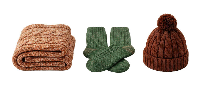 Autumn knitwear set featuring a folded peach blanket green socks and brown hat with pompom isolated on transparent background.