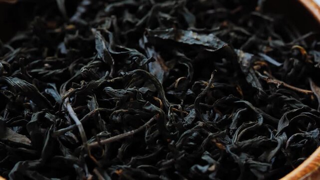 Dried black tea leaves in a wooden bowl