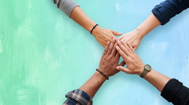 Diverse group of people with hands together symbolizing unity and teamwork