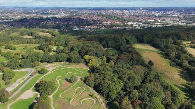 Aerial video looking north across the winding mountain bike trails, pump tracks, and extensive woodland of Middleton Park towards