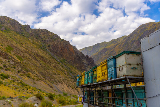 Colorful beehives on metal platform in mountainous landscape