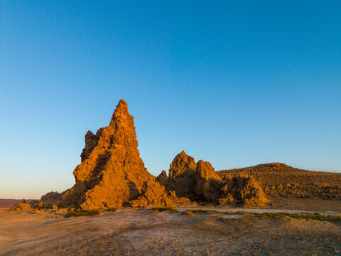 A tall limestone chimney rock formation stands beneath a clear blue sky, Afar depression, Lake Abbe, Djibouti