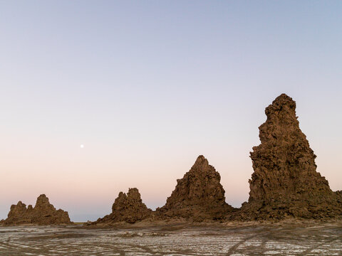 Multiple limestone chimney rock formations rise from the salt flat at twilight, Afar depression, Lake Abbe, Djibouti