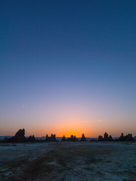 The sun sets behind limestone chimney rock formations on the horizon, Afar depression, Lake Abbe, Djibouti