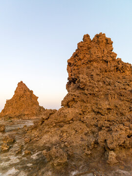 Two limestone chimney rock formations rise from the desert at dusk, Afar depression, Lake Abbe, Djibouti