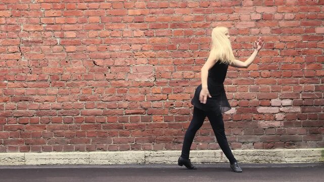 Girl moves gracefully near old wall in Lisbon alley