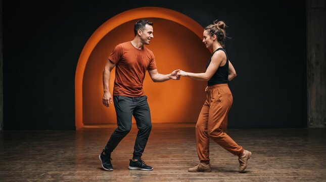 Two adult Merengue dancers traveling diagonally across indoor studio with authentic rhythmic footwork, monumental orange arch background warm spotlight cinematic
