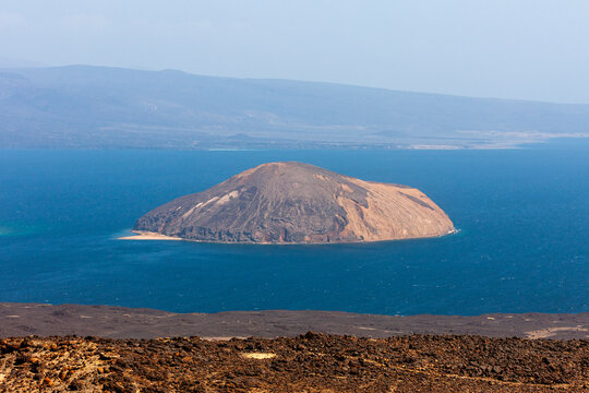 A cone-shaped volcanic island sits alone in the blue waters of the Devil's Cauldron, Tadjourah Region, Goubet Al-kharab, Djibouti
