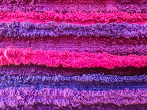 Colorful striped textile fabric showing vibrant pink and purple