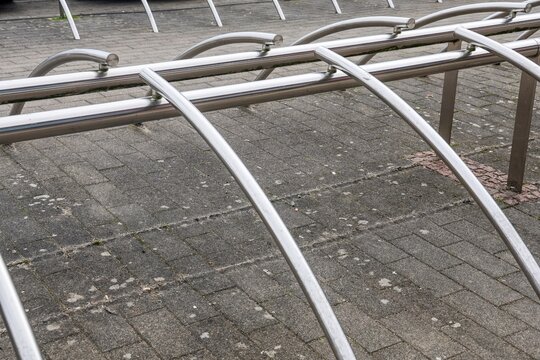 Empty metallic bicycle rack on paved surface